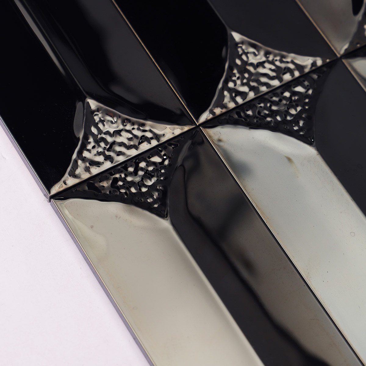 Macro close-up of 3D black mirror metal rectangle mosaic tiles.
