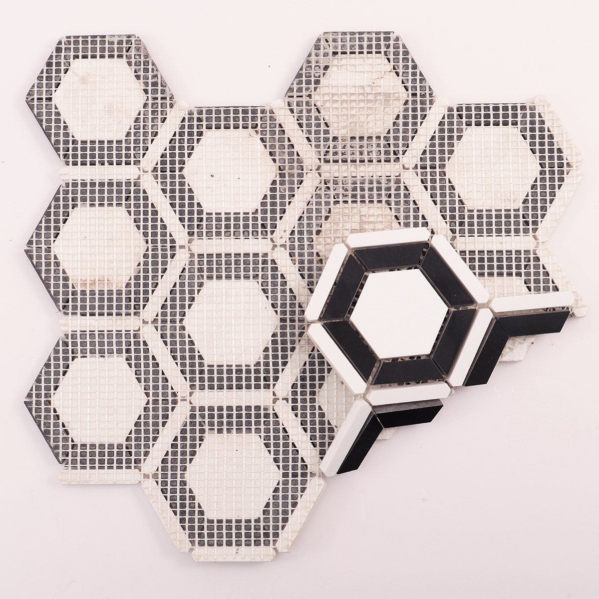 Back side of white and black hexagon marble mosaic tiles, folded.