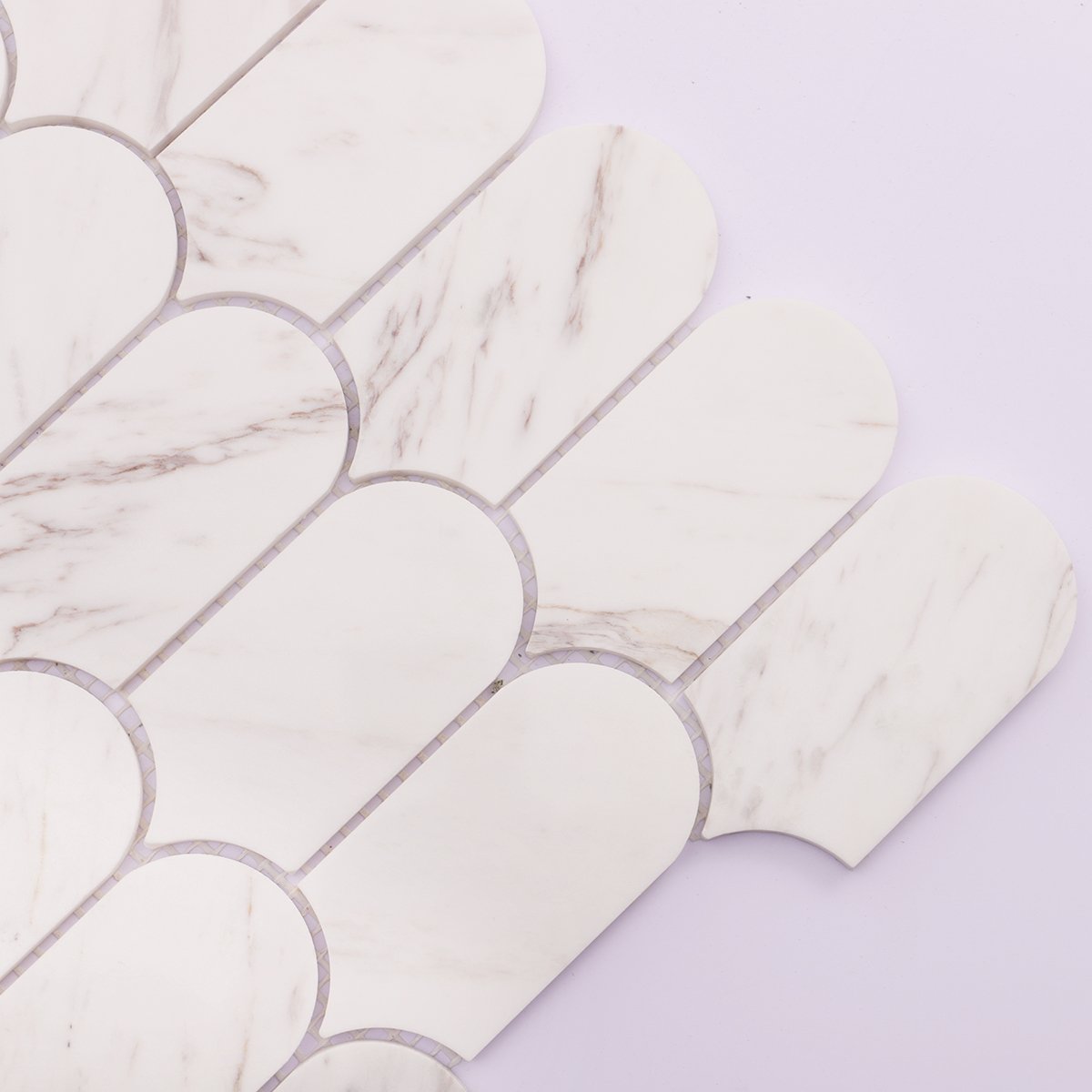 Detailed view of white marble mosaic tile, highlighting soft veins and polished finish