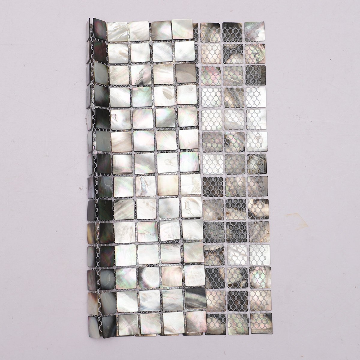 Back side of deep sea black seashell square pattern mosaic tiles, showing fold