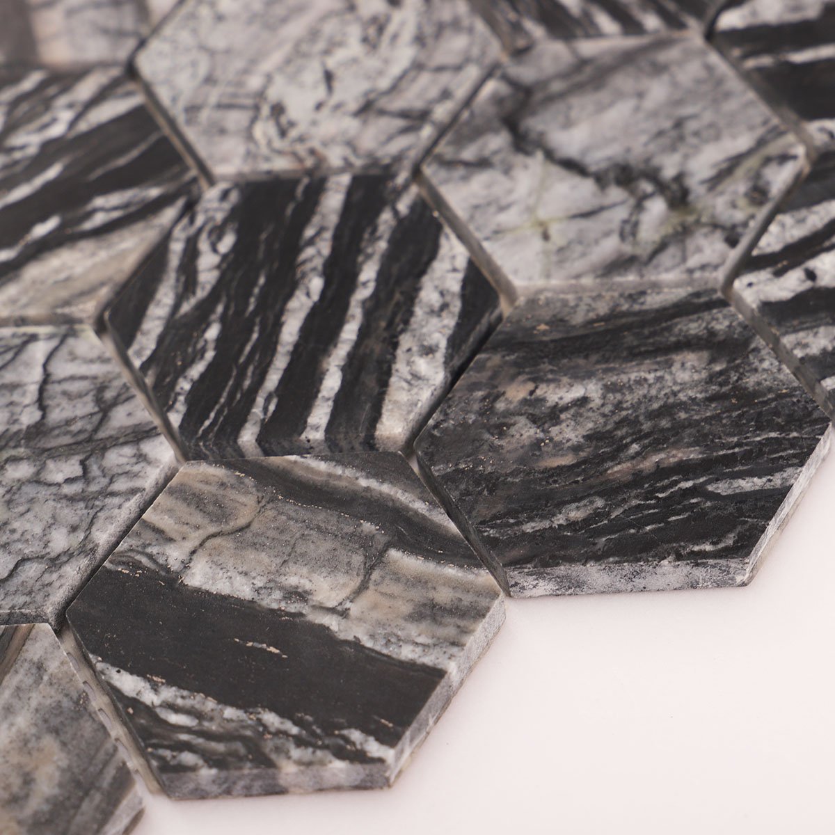 Side close-up view of dark grey hexagon marble mosaic tiles, showing texture and thickness.