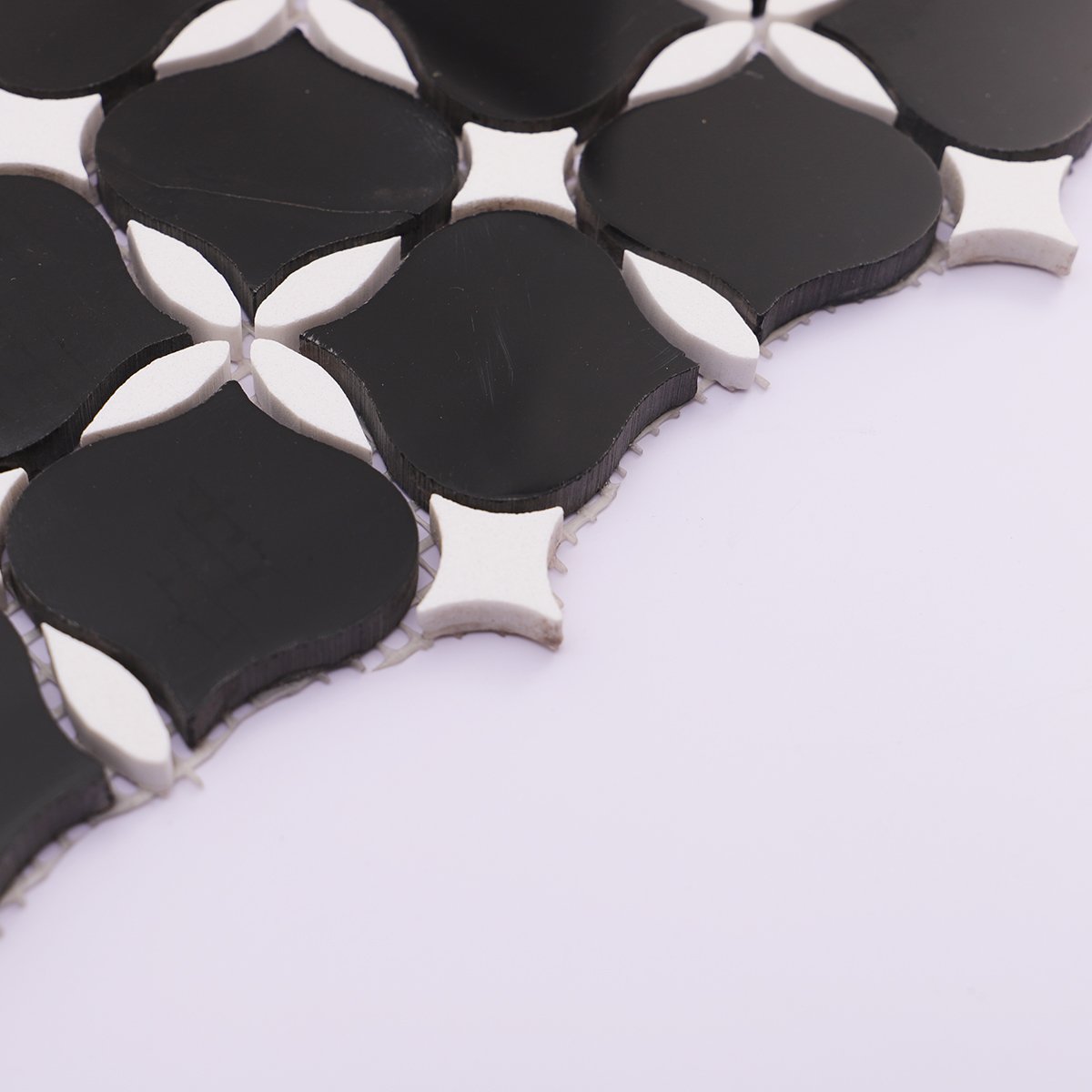 Side view of black and white stone mosaic tiles, showing the thickness and texture of each tile