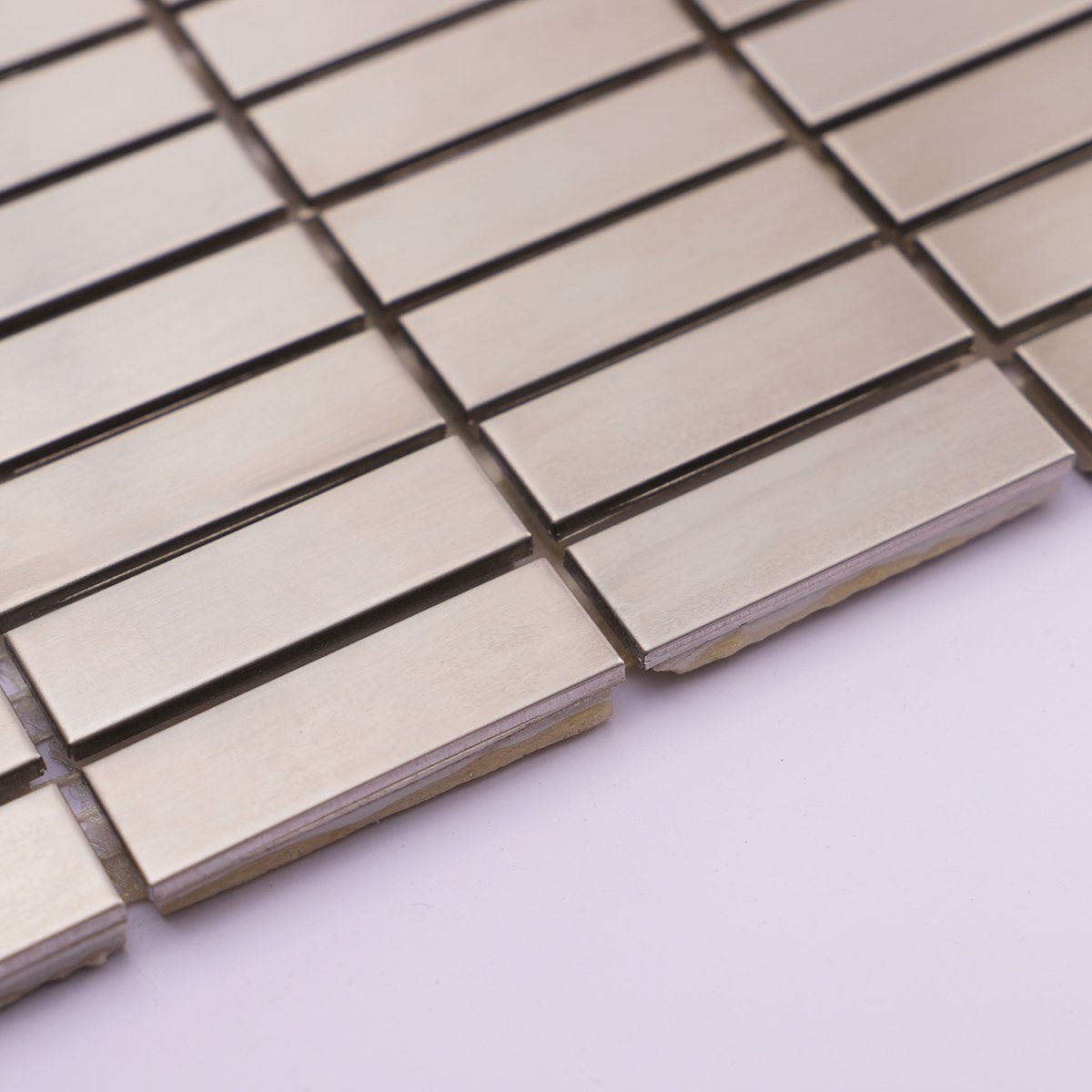 Side profile showcasing the thickness of silver stainless steel rectangle tiles.