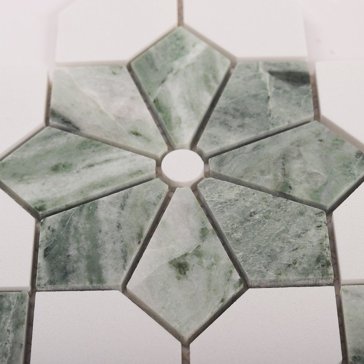 Close-up view of Ming green and white floral marble mosaic tiles.