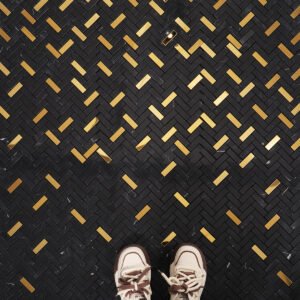 Black marble and gold metal gradient mosaic tiles in a stylish living room.