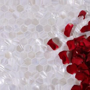 White hexagon mother of pearl mosaic tiles with rose petals beside them.