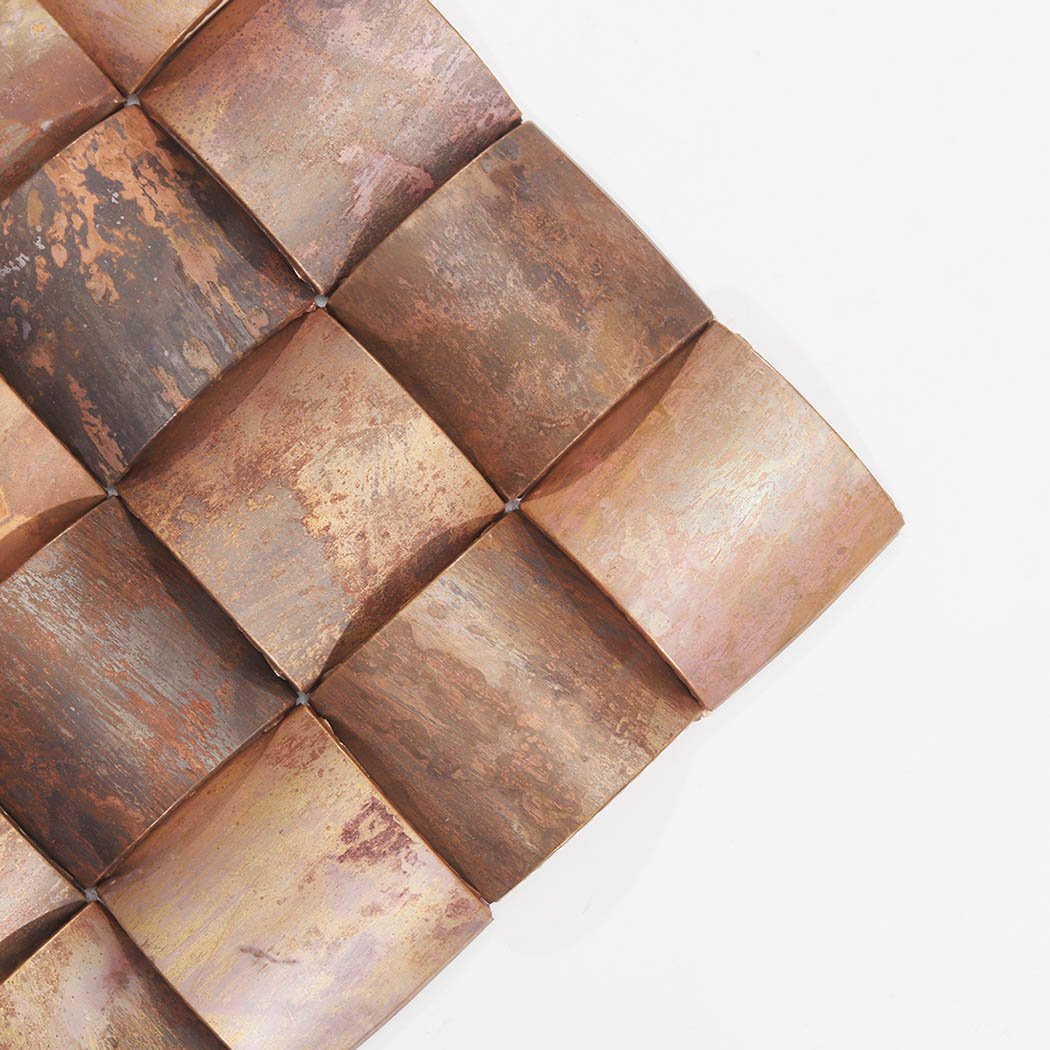 Corner detail of antique copper 3D square metal mosaic tile with aged patina