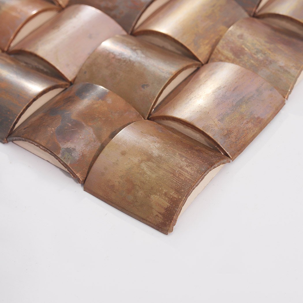 Side edge of antique copper 3D square metal mosaic tile showing raised texture