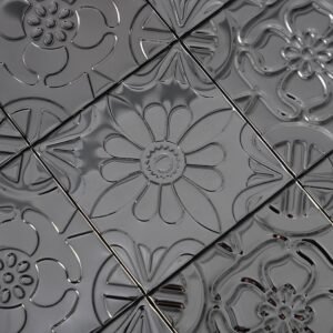 Svart metallmosaik i lapptäcksmönster med präglade blommotiv