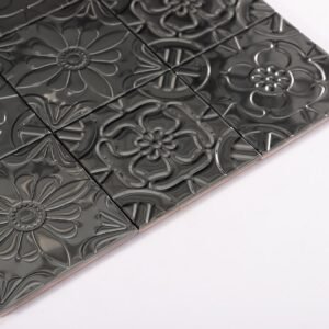 Svart metallmosaik i lapptäcksmönster med präglade blommotiv