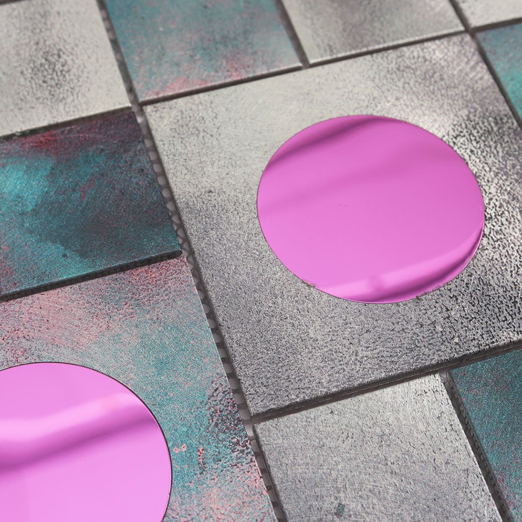 Close up of aluminum mosaic tile with textured silver surface and pink glass circle