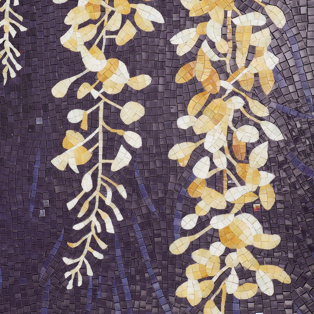 Gold and white vine flowers arranged over a deep blue mosaic mural surface