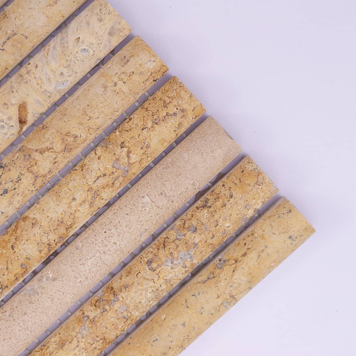 Corner close-up of beige fluted travertine mosaic tile