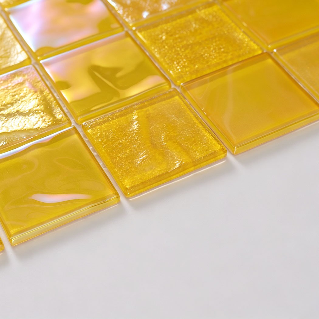 Detailed view of bright yellow iridescent square glass tiles with luminous reflections
