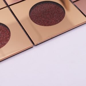 Rund mosaikflise med rosaguldfarvet metal og rødt glitterglas