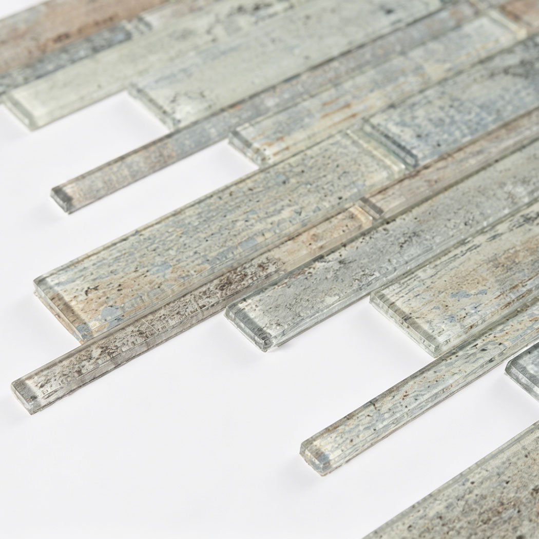 Low angle detail of rustic gray beige glass mosaic with staggered strip layout