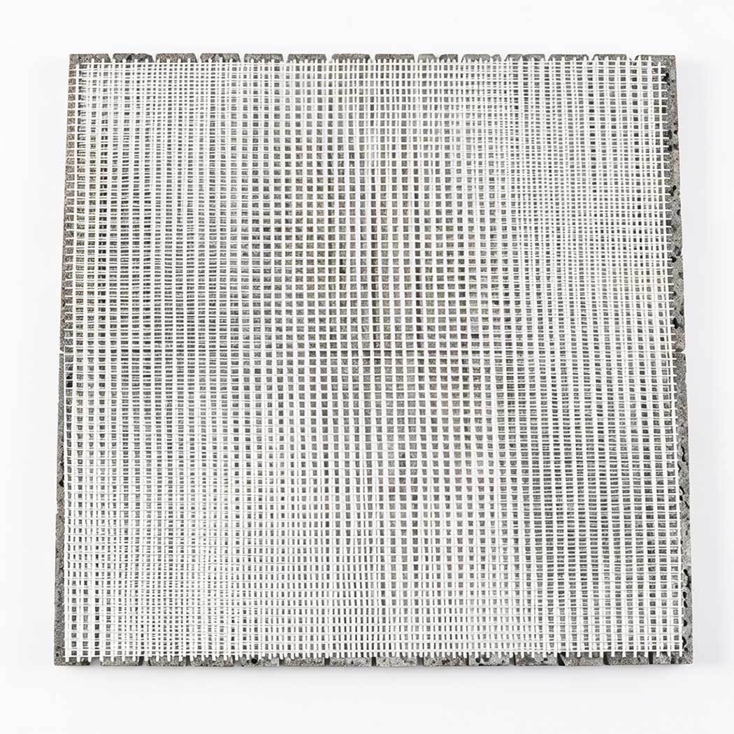 Back view of gray lava stone linear mosaic tile sheet with white mesh backing
