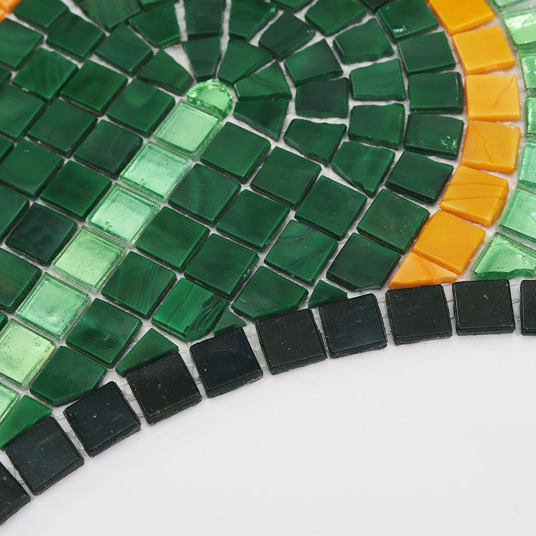 Close-up of textured green and orange glass mosaic tiles.