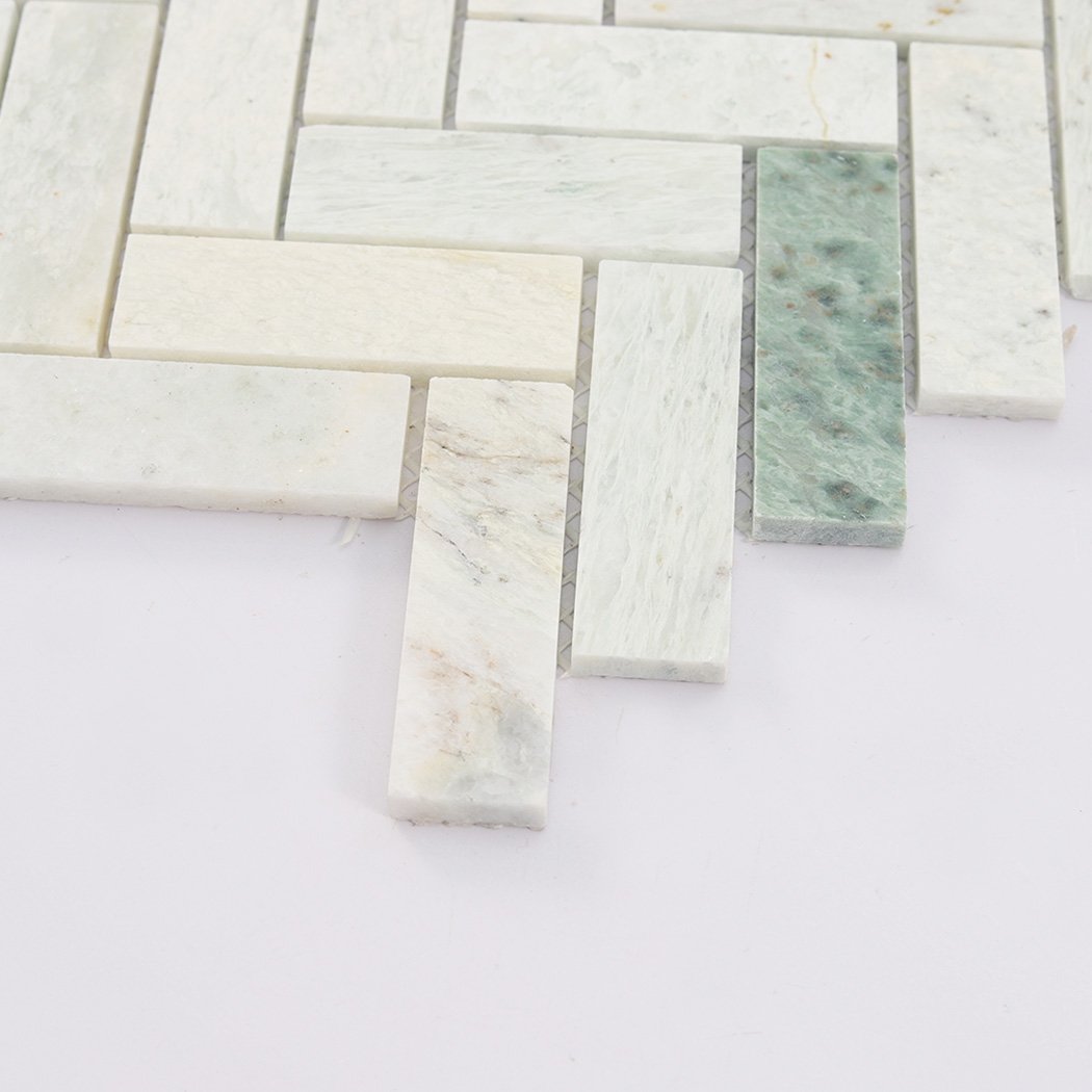 Side close up of light green herringbone marble mosaic tile showing thickness