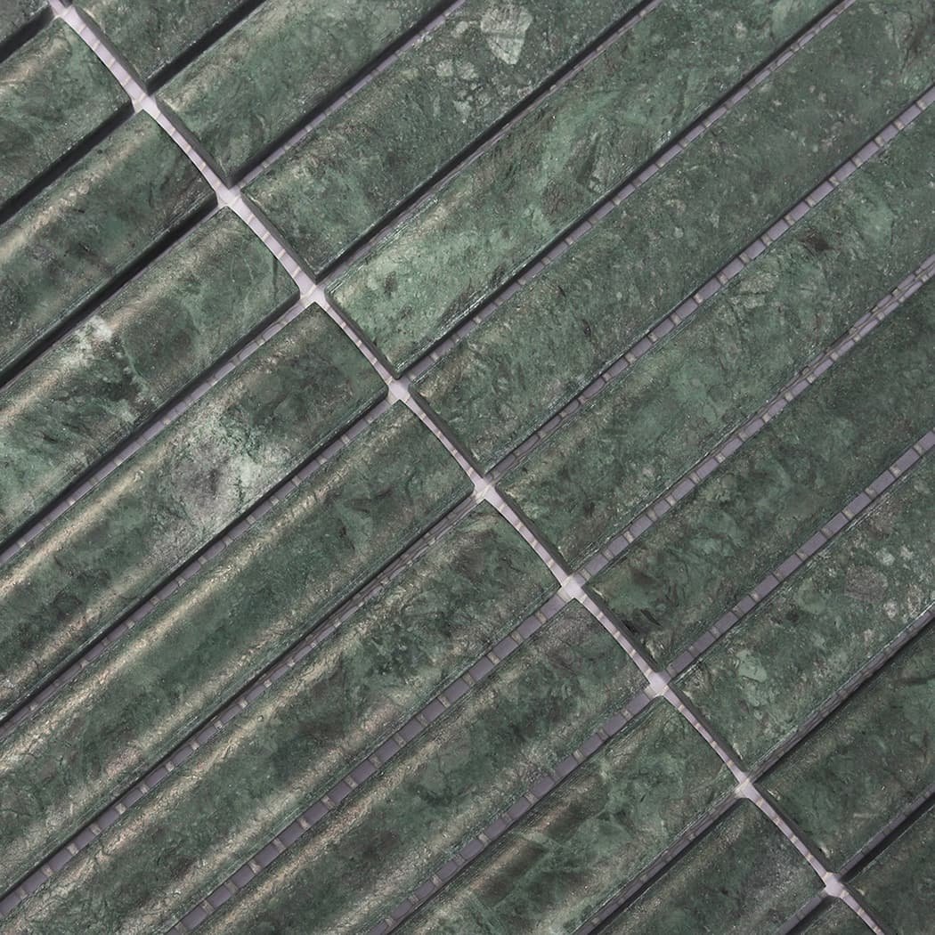 Macro shot highlighting the rounded edges and polished surface of green marble tiles.