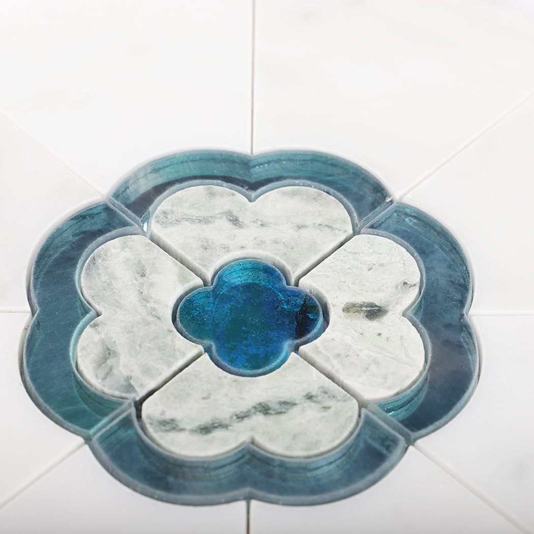Close up of blue flower medallion made from glass and marble on white tile