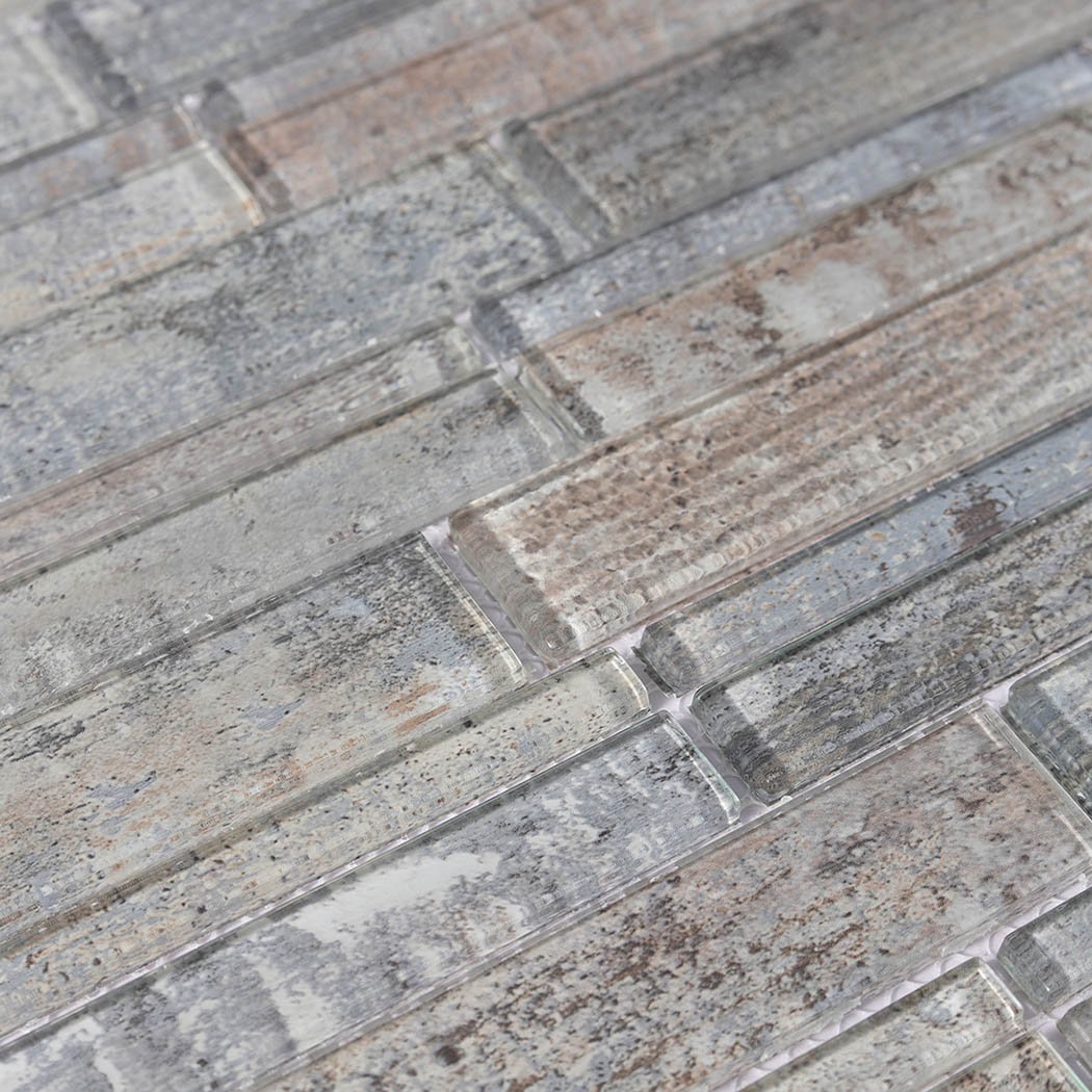 Macro view of mottled gray beige linear glass mosaic strips on mesh