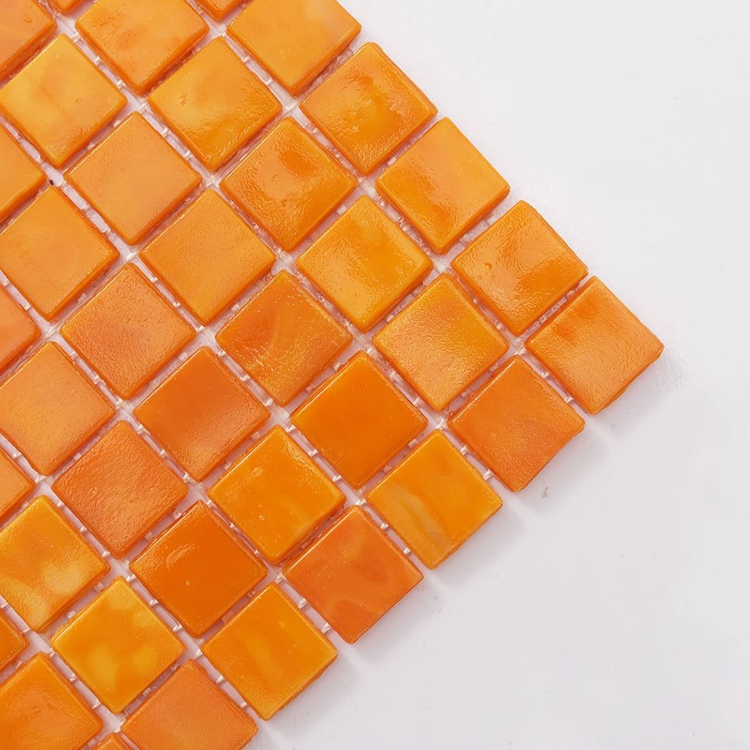 Corner close-up of orange yellow square glass mosaic tile with glossy finish