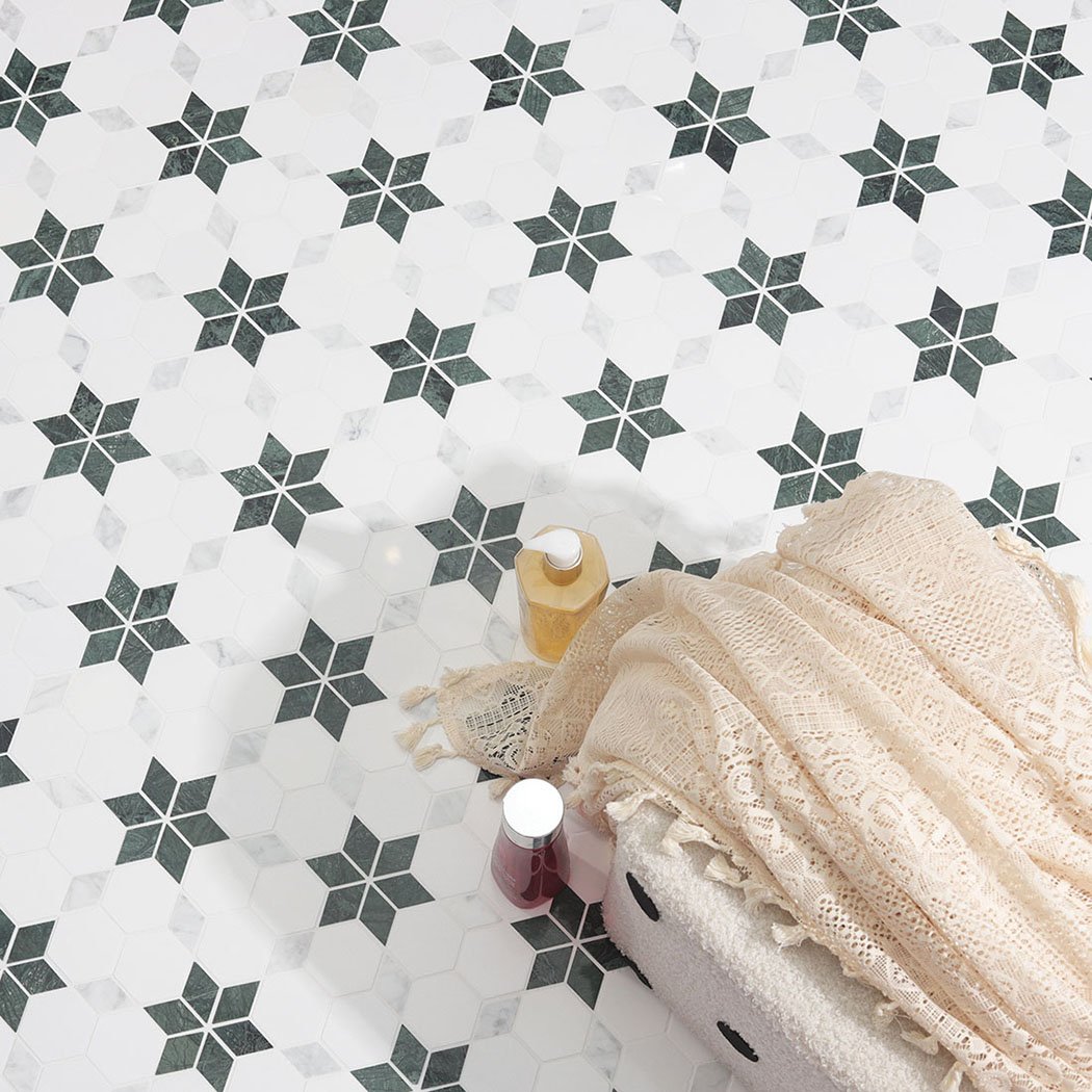 Top-down view of dark green star pattern marble mosaic tiles and lifestyle props.