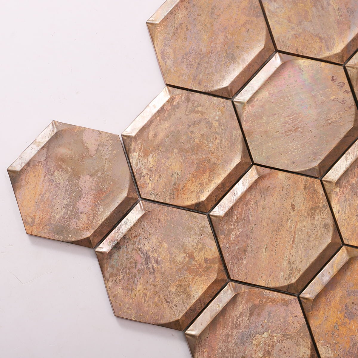 Close-up of vintage bronze hexagon mosaic tiles showcasing textured surface and patina