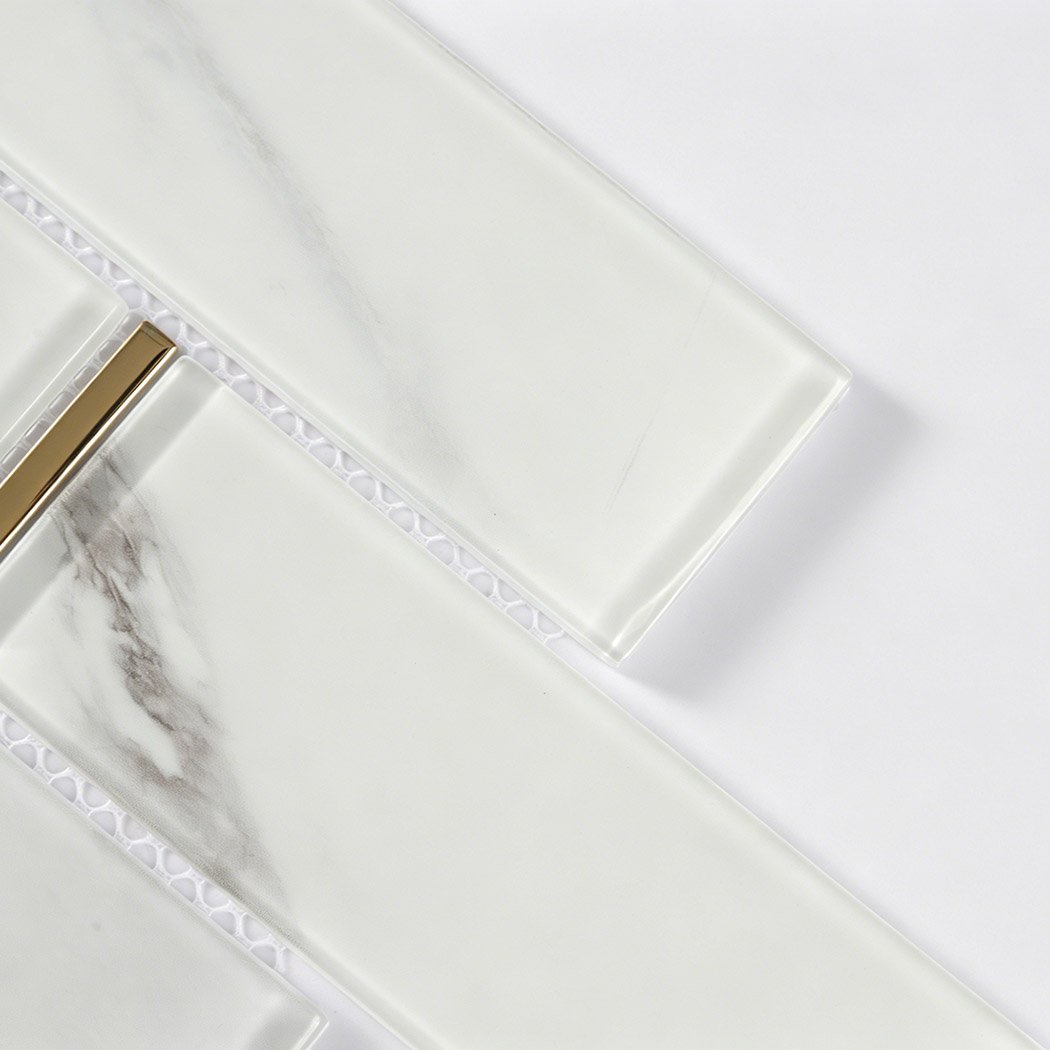 White marble glass subway tile detail with beveled edges and metallic gold accent